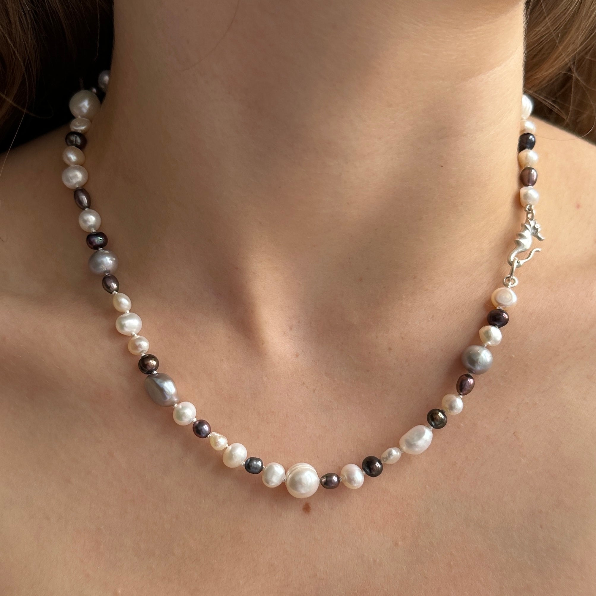 Ferskvandsperlekæde i hvis og blå med søhestlås i 925 sølv